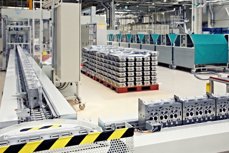 Modern industrial manufacturing facility, automated lines, engine parts, clean durable floor.