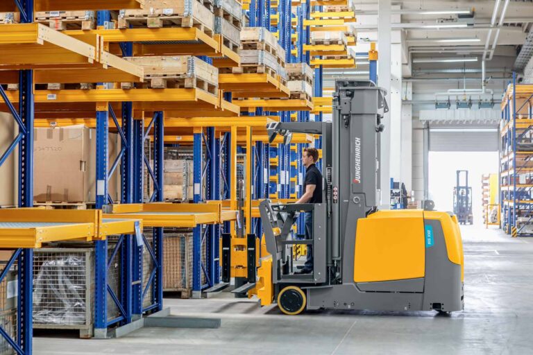 Operator on Jungheinrich reach truck, industrial warehouse, durable flooring solution