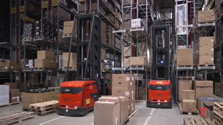 Automated forklifts busy warehouse, high racking, durable industrial concrete flooring.