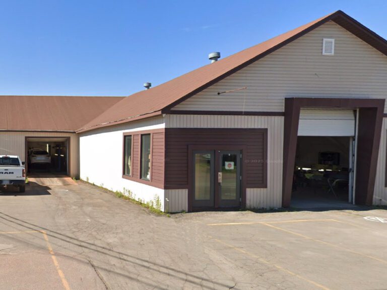 Industrial building, multiple garage doors, customer entrance, tan brown exterior.