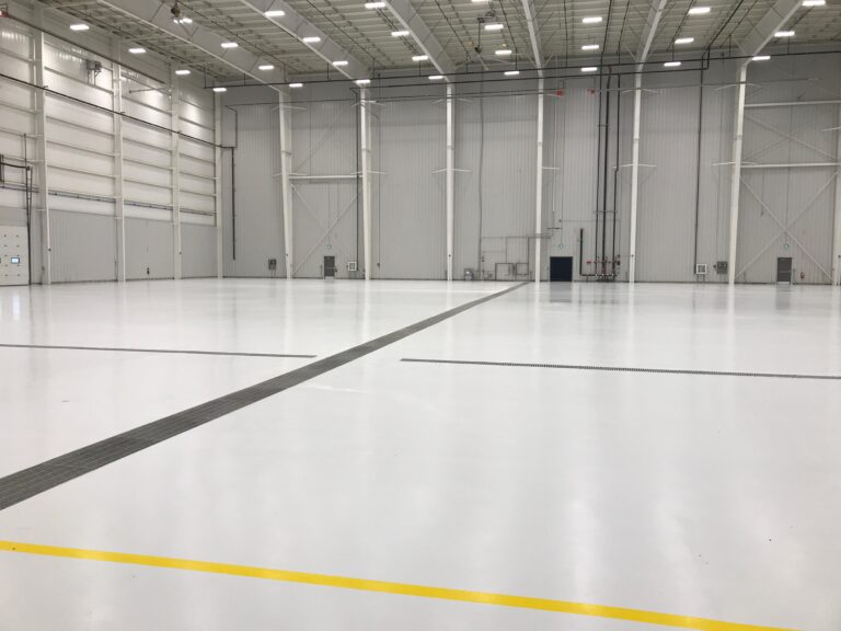 Industrial facility, pristine white epoxy floor, floor drains, yellow safety line