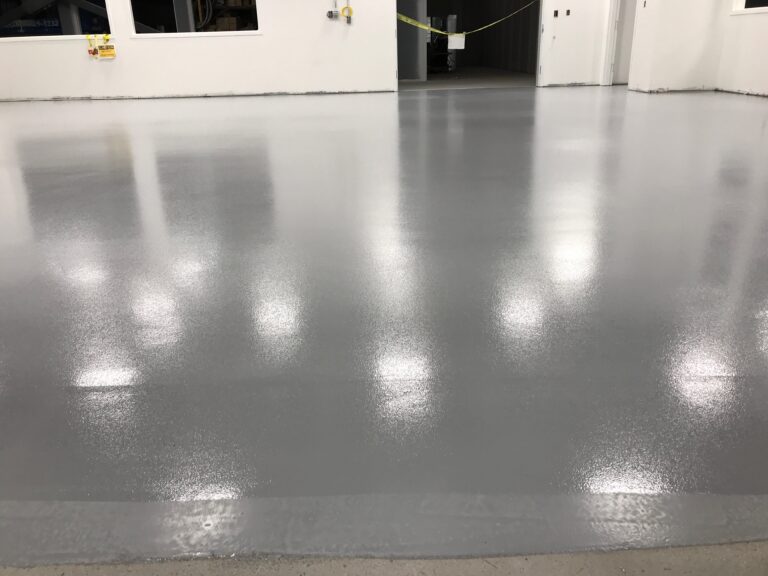Sol en époxy industriel gris, finition brillante, espace commercial durable.